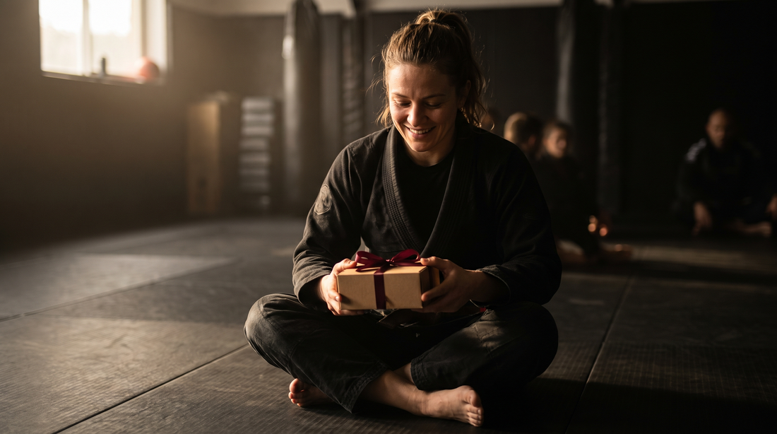 Woman in a BJJ gi holding a red-ribbon gift box